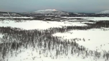 İnsansız hava aracı, Norveç 'in çarpıcı kış manzarasını görüntüledi ve geniş bir karlı manzarayı gözler önüne serdi. Görünür ağaçlar el değmemiş karı noktalıyor, sakin bir İskandinav kış atmosferi sunuyor..