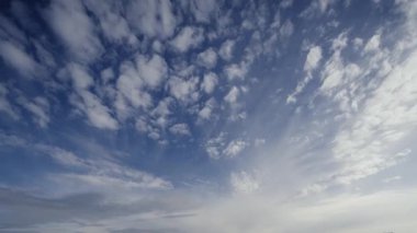 Canlı bir zaman dilimi bulutların dinamik dönüşümünü yakalıyor, gökyüzünün mavi gökyüzüne karşı gelişen geniş açılı görüntüsünü gösteriyor.