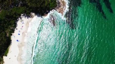 Avustralya 'nın Jervis Körfezi' nde yemyeşil, el değmemiş plajlar ve berrak turkuaz suların yer aldığı kıyı kasabasının havadan görünüşü. Sahil boyunca evler var. Huzurlu ve resimli bir manzara sunuyorlar..