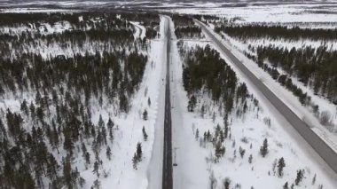 İsveç 'in Kiruna kenti yakınlarındaki yoğun karlı ormanlarda yol ve demiryollarının sakin bir kış manzarasını görüntüleyen İHA görüntüleri, manzaranın keskin ve sessiz güzelliğini vurguluyor..