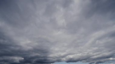 Geniş açılı bir zaman dilimi videosu gökyüzündeki bulutların dramatik hareketini gösteriyor, doğal akışı ve hava değişimlerini vurguluyor..
