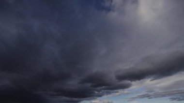 Gökyüzünde yoğun, karanlık fırtına bulutlarının dramatik ve hızlı bir şekilde toplandığını gösteren bir zaman kaydıyla yaklaşan fırtınayı gösteriyor..