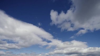 Geniş açılı zaman dilimi videosu bulutların berrak, mavi gökyüzüne doğru pürüzsüz bir şekilde sürüklenen nefes kesici hareketini yakalıyor..