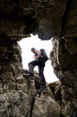 Bir yürüyüşçü Meksika 'daki La Malinche Ulusal Parkı' nda engebeli kayalara tırmanır. Sırt çantasıyla donatılmış maceraperest, kayalık arazide kararlılıkla gezinir..