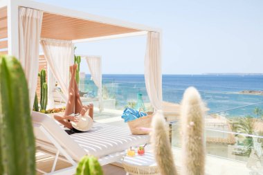 Yaz tatilinde güneşli bir günde güneşli bir havada güneşli bir yatakta uzanırken güneşli bir yatakta güneşli bir şapkayla yüzünü örten isimsiz bir kadın.