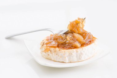 Zarif keçi peynirli rulo zarif bir katman karamelize soğan ile kaplanmış, gümüş çatal ile beyaz bir tabakta servis enfes bir mutfak sunumu için