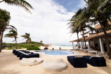 Cozumel Adası 'ndaki lüks sahil konaklamaları, rüzgarlı palmiye ağaçları altında güneşlenen ve Karayip Denizi' ne bakan güneşli bir havuz içeriyor..