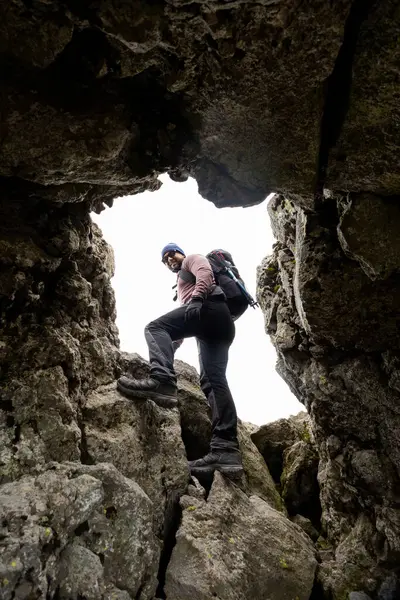 Bir yürüyüşçü Meksika 'daki La Malinche Ulusal Parkı' nda engebeli kayalara tırmanır. Sırt çantasıyla donatılmış maceraperest, kayalık arazide kararlılıkla gezinir..