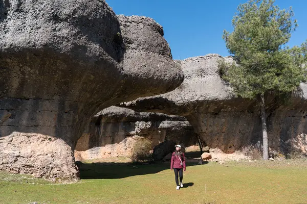 La Ciudad Encantada, Cuenca, Castilla-La Mancha, İspanya 'da yürüyen genç Asyalı kadın, açık mavi gökyüzü altında eşsiz kaya oluşumlarıyla çevrelenmiş..