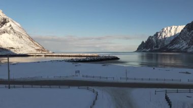 Norveç, Ersfjord 'da nefes kesici bir kış sahnesi karla kaplı zirveler ve sakin doğal güzelliği yansıtan sakin buzlu suları gözler önüne seriyor.