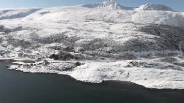 Karlı tepeler ve sakin bir fiyort Norveç 'in Laukvikan Ranta şehrinde nefes kesici bir kış manzarası yaratır. El değmemiş kar zemini örtüyor. Huzur ve doğal güzellik hissi veriyor.