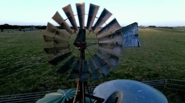 Victoria, Avustralya 'da geniş, açık bir alanda duran geleneksel bir yel değirmeninin pitoresk bir görüntüsü. Arazi, berrak bir gökyüzünün altında yemyeşil çimlerle çok uzaklara uzanır..