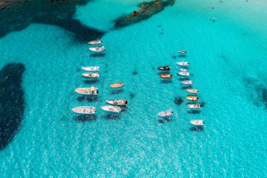 Yazın mavi denizde güzel lüks bir yat ve tekne manzarası. Sardunya, İtalya. Sürat teknesi, deniz bölmesi, şeffaf turkuaz su. Seyahat et. Tropikal renkli manzara. Yat.