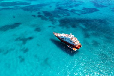 Yazın mavi denizde güzel lüks bir yat ve tekne manzarası. Sardunya, İtalya. Sürat teknesi, deniz bölmesi, şeffaf turkuaz su. Seyahat et. Tropikal renkli manzara. Yat.