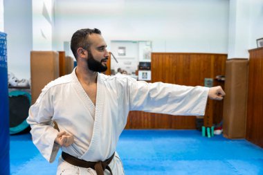 Karate pratisyeni, geleneksel dojo ortamında belli bir yumruk tekniği uyguluyor, güç ve kontrol gösterisi yapıyor.