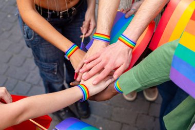 Eller birleşiyor, gökkuşağı bilezikleri takıyor, birliği ve Igbtq artı topluluğa desteği simgeliyor.