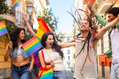 Bir lgbtq + geçit töreninde coşkuyla kutlama yapan bir grup genç aktivist, çeşitliliği kucaklıyor ve canlı enerji ile eşit hakları destekliyor.