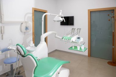 Modern ekipmanlar, bir diş sandalyesi ve enstrümanlarla dolu boş bir dişçi ofisi. Hepsi bir sonraki hastalar için hazırlandı.