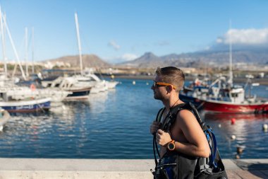 Dalgıç dalış ekipmanları taşıyor marinada dalış teknesine doğru yürüyor