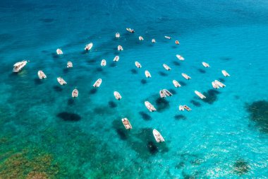 Yazın günbatımında mavi denizde birçok motorlu teknenin hava görüntüsü. Sardunya, İtalya 'ya seyahat. Sürat tekneleri, yatlar, okyanus, şeffaf gök mavisi su. Tropik deniz manzarası
