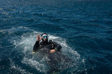 Scuba dalgıcı dalıştan sonra suyun yüzeyinde 