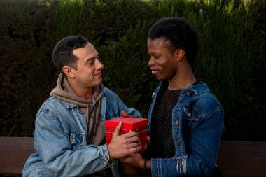 Parktaki bankta otururken birbirlerine hediye veren sevgilileri sevmek.