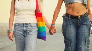 İki kadın el ele tutuşuyor ve sokakta yürüyor, lgbtq artı haklara olan sevgilerini ve desteklerini ifade ediyorlar.