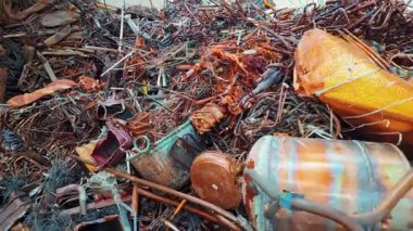 Borular, kablolar ve konteynırlar da dahil olmak üzere büyük bir metal yığını, bir geri dönüşüm tesisinde işlenmeyi bekliyor ve sürdürülebilirlik için metal geri dönüşümünün önemini gösteriyor..