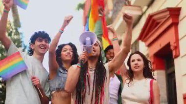 Çeşitli genç aktivist grupları lgbtq + hakları için birlikte yürüyorlar, gökkuşağı bayrakları sallıyorlar ve megafon kullanıyorlar.