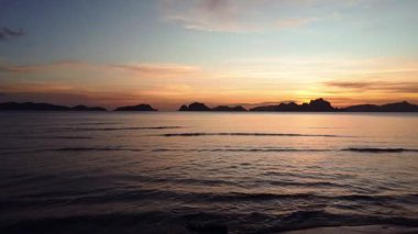 Sakin bir günbatımının nefes kesici hava manzarası sakin okyanus dalgalarının üzerine canlı renkler döküyor. Filipinler 'de yakalanan bu sakin sahne doğanın güzelliğini somutlaştırıyor..