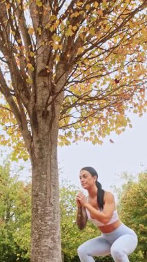 Yeni Zelanda 'daki bir sonbahar parkında egzersiz yapan bir kadın. Sahne, mevsimsel güzelliğin altını çizerek sonbahar yeşilliği ve fitness aktivitesinin canlı bir karışımını yakalıyor..