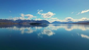 Yeni Zelanda 'nın Canterbury bölgesindeki Tekapo Gölü' nün nefes kesici manzarası, bulutlu gökyüzünü yansıtan el değmemiş suları ve sakin bir manzarayla çevrili dağları gösteriyor..