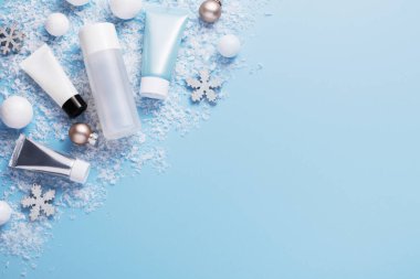 Kış cilt bakımı ve kozmetik ürünleri ile güzellik konsepti ve mavi arka planda tatil temalı dekorasyonlar, üst görünüm, kopyalama alanı
