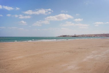 Arka planda Sur şehrinin mavi gökyüzü ve şehir manzaralı güzel bir sahil manzarası, Umman.