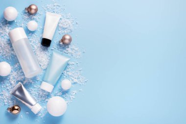 Kış cilt bakımı ve kozmetik ürünleri ile güzellik konsepti ve mavi arka planda tatil temalı dekorasyonlar, üst görünüm, kopyalama alanı