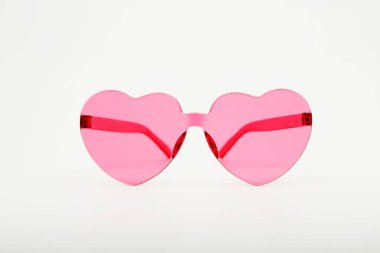 Beyaz arka planda pembe kalp şeklindeki güneş gözlüklerinin stüdyo çekimi