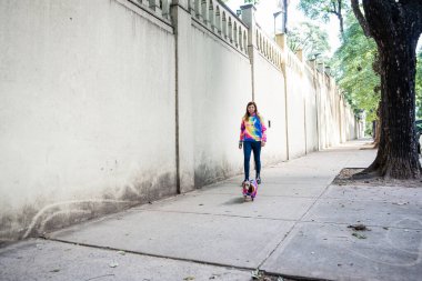 Köpeğini gezdiren Latin bir kadın, ikisi de aynı giyinmiş. Gri arka plan. Boşluğu kopyala