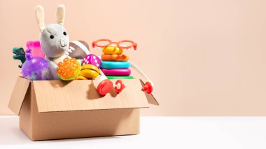 Bej arka planda bağışlanmaya hazır çocuklar için oyuncaklar, minimum yaşam tarzı. Oyuncak bağışları, çocuklara yardım, fotokopi alanı