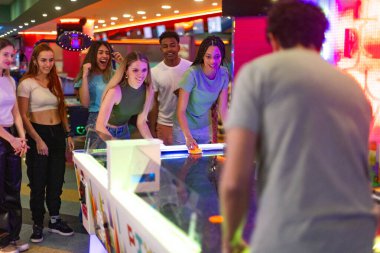 Atari salonunda hokey oynayan bir grup genç, boş zamanlarının tadını çıkarıyorlar.