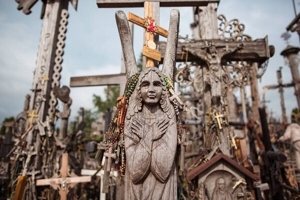 Деревянная скульптура ангела с четками и крестами на холме Крестов, Литва