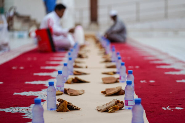 Общинная трапеза во дворе мечети Джидда - мусульмане делятся едой после молитвы, Саудовская Аравия