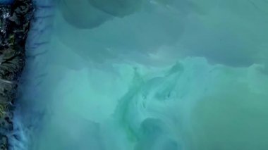 Rotorua, Yeni Zelanda 'da canlı termal renklerin ve benzersiz oluşumların havadan görünüşü. Jeolojik aktivite, dumanı tüten havuzlar ve renkli mineral yataklarından oluşan gerçeküstü bir manzara yaratır.