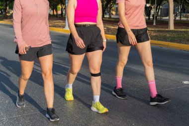 Tanımlanamayan bir grup kadın güneşli bir günde atletizm kıyafetleriyle dışarı çıkıyorlar.