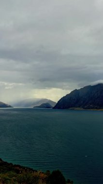 Sonbaharda Wanaka Gölü 'nün sakin güzelliğini dramatik bulutlar ve dağlık ufuklarla yakalamak. Fotoğraf dinginliği ve doğal ihtişamı çağrıştırıyor..