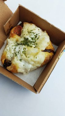 Lezzetli sosislerle dolu yumuşak ekmek ve özel baharatlı sos.