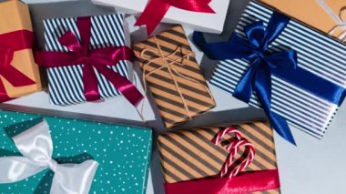 Gri arka planda kurdeleli bir sürü Noel hediyesi kutusu. Hareket animasyonunu durdur. Mesaj için yer var. Model.