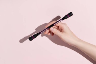 Woman hold pen spinning in your hand on pink background. Hand motor skills. High quality photo