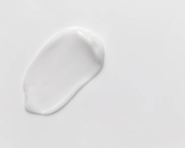 White beauty cream smear smudge on white background. Cosmetic skincare product texture. Face cream, body lotion swipe swatch