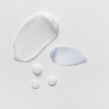 Blue and white beauty cream smears smudge on white background. Cosmetic skincare products texture. Face cream, body lotion swipe swatch