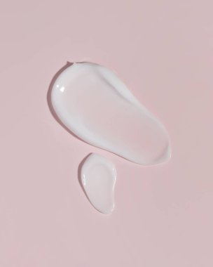 Pembe arka planda kozmetik krem dokusu. Kozmetik cilt ürünü dokusu. Yüz kremi, vücut losyonu sürgüsü..